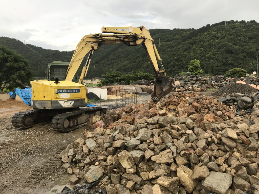 ユンボで、石をすくい上げます