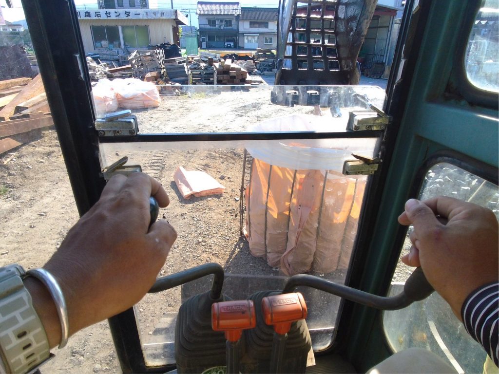 ユンボでフレコンに割栗石を入れてます。