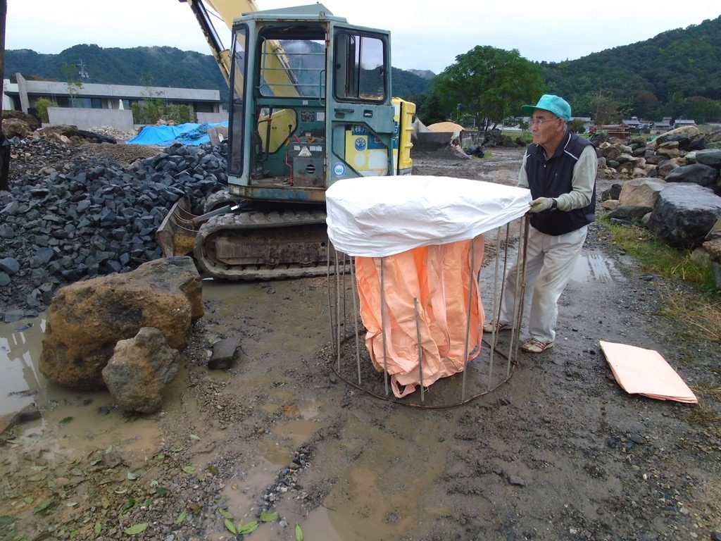 フレコンに揖斐青黒割栗石を詰め込みます