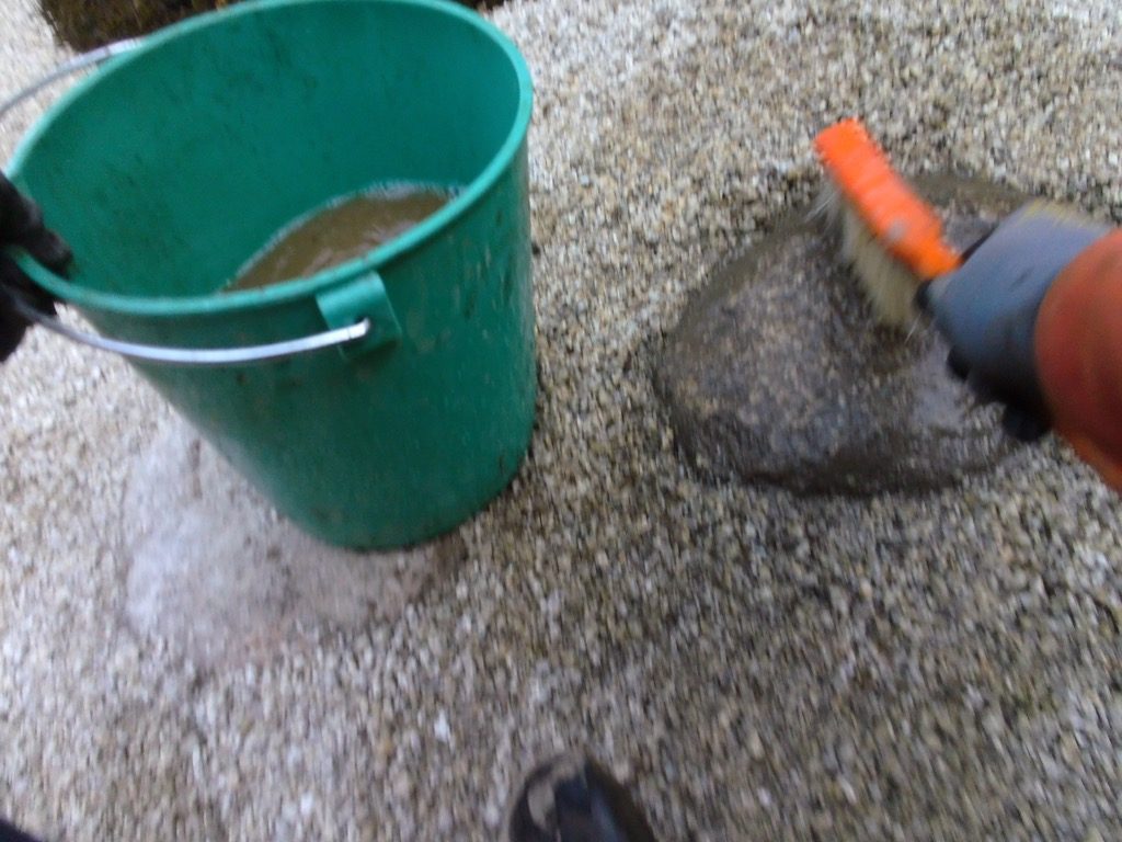 景石や飛石に着いた土汚れをデッキブラシで落としていきます