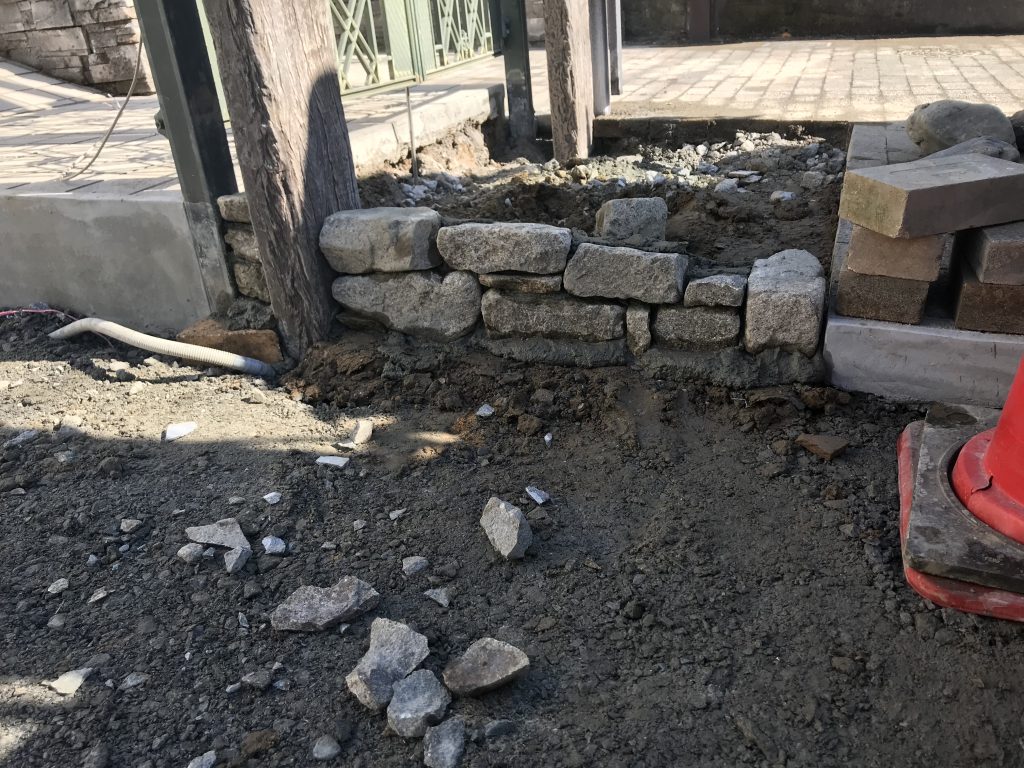 土間コンクリートを打設する際に、門扉前のアプローチを和良石で張っていくため、側面だけ先に積んでおきます